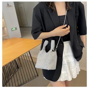 Stylish silver rhinestone bucket bag with chain strap shown on model in black blazer