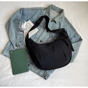 Detailed lifestyle shot of a black large capacity dumpling crossbody bag on a denim jacket