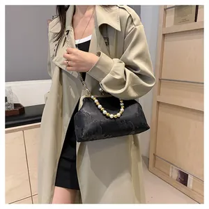 Stylish New Chinese style black beaded handbag with pearl handle on model.