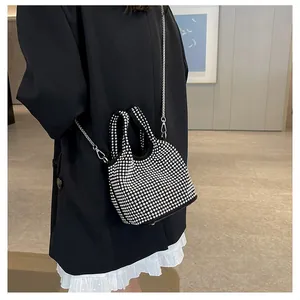 Elegant sparkly black rhinestone bucket bag with silver chain strap worn by model