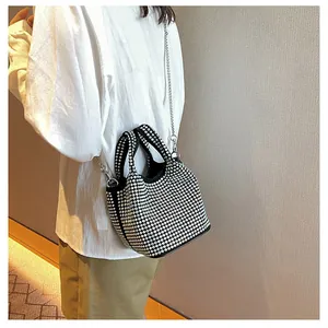 Sparkling black rhinestone bucket bag with silver chain strap shown in detail on model