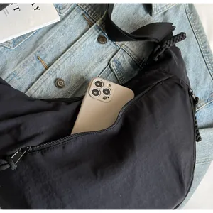 Macro view of black crescent crossbody bag showing ample internal smartphone storage