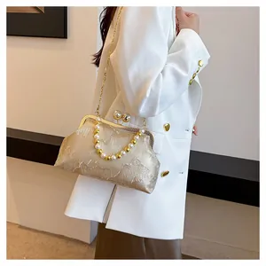 Elegant "New Chinese" style clutch bag with pearls and mountain pattern on a model.