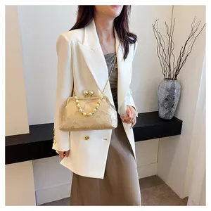 Model carrying an elegant New Chinese style embroidered handbag with pearl chain detail