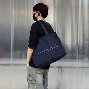 Detalle de cerca del bolso de hombro de nailon azul marino con texto en un modelo asiático