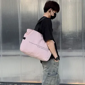 Vista lateral de un bolso tote de nailon rosa de gran capacidad llevado por un modelo