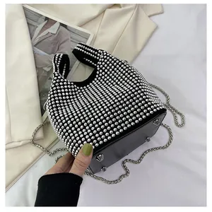Close-up of black rhinestone bucket bag with chain strap and metal feet.