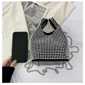 Close-up of black rhinestone bucket bag with silver chain strap and metal feet