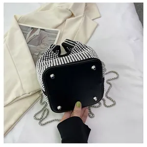 Close-up detail of the leather bottom with silver studs on a rhinestone bucket bag