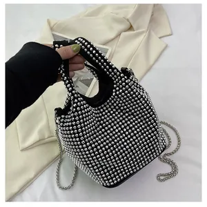 Detailed view of a black bucket bag adorned with shimmering silver rhinestones and chain.