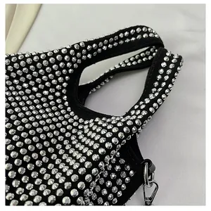 Close-up detail of luxury black bucket bag featuring dense silver rhinestone pattern.