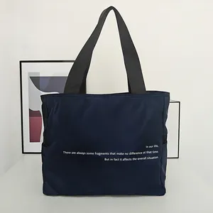 Elegante bolso tote de nailon azul oscuro con frase minimalista impresa en la parte frontal