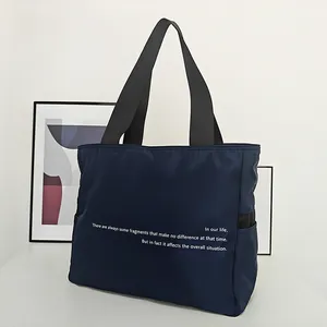 Vista detallada del bolso de hombro de nailon azul marino con elegante texto blanco