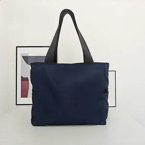 Vista frontal de un bolso tote de nailon azul minimalista en un interior moderno.