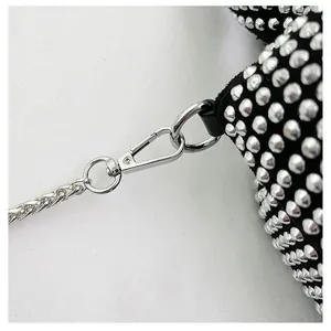 Close-up of silver metal chain strap and lobster clasp on black rhinestone bag
