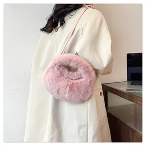 Primer plano de bolso rosa de piel sintética con correa fina y textura de pelo suave