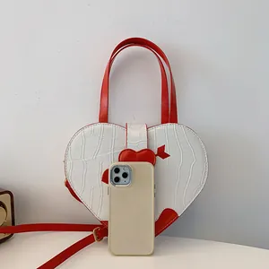Detail of white heart-shaped handbag with crocodile texture and scale comparison