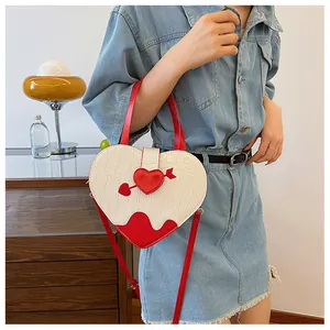 Trendy crocodile embossed heart-shaped handbag in white and red color being carried