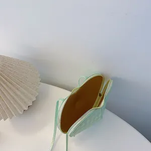 Detailansicht der mintgrünen herzförmigen Stepptasche mit braunem Innenfutter
