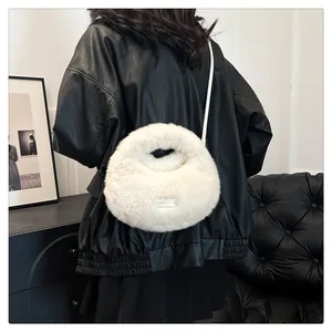 Vista trasera de un bolso bandolera de felpa blanca sobre una chaqueta de cuero negra