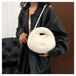 Detalle de bolso de mano de piel sintética blanca con etiqueta sobre chaqueta