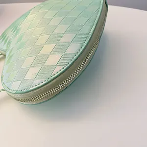 Detaillierte Nahaufnahme der grünen herzförmigen Tasche mit Rautenmuster-Textur