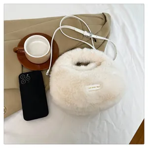 Primer plano de un bolso de peluche crema sobre un fondo de chaqueta beige elegante