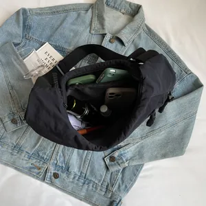 Large capacity black casual dumpling shoulder bag shown open with everyday items inside