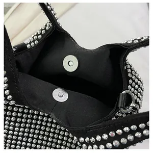 Detailed view showing the magnetic button closure and fabric lining of this rhinestone bag