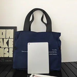 Bolso tote de nailon azul marino de gran capacidad mostrado junto a una tableta digital