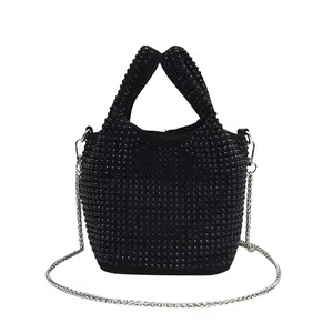 Detailed view of the black rhinestone bucket bag with silver chain strap
