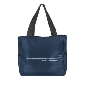 Bolso tote grande y versátil de nailon azul marino con asas negras y texto blanco