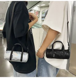 Lifestyle detail of silver and black mini cylindrical crossbody bags on models in a mall.