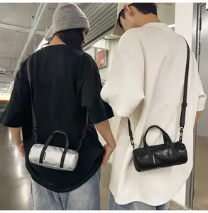 Macro view of mini cylindrical crossbody bags in silver and black worn by Asian models