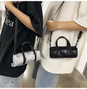 Detail of mini cylindrical crossbody bags in iridescent silver and shiny black