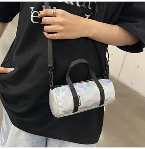 Close-up of a mini holographic cylindrical crossbody bag worn by a stylish model.