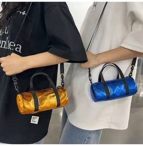 Detail of metallic cylinder mini crossbody bags worn by models in gold and blue.