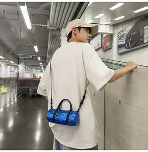 Stylish blue mini cylindrical crossbody bag shown on a model in an urban station.