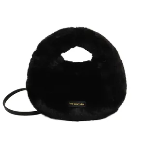 Vista detallada de bolso tote negro de felpa con etiqueta dorada love every day