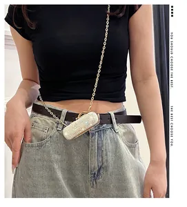 Close-up of a sparkling silver sequined mini lipstick bag with a gold chain strap