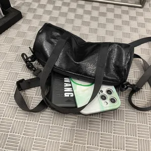 Minimalist black shiny mini crossbody bag for daily essentials and phone storage.