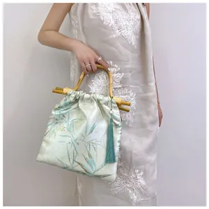 Dettaglio di borsa in stile cinese con manici in bambù ed elegante stampa floreale