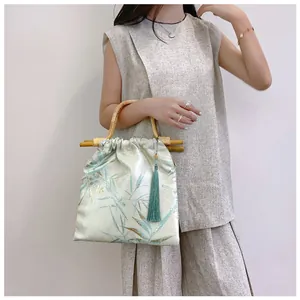 Dettaglio borsa in stile cinese con manico in bambù ed elegante nappa di seta