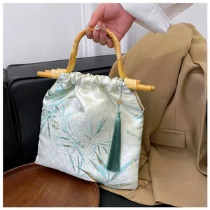 Primo piano dettagliato di una borsa vintage in raso stile cinese con manico in bambù e nappa