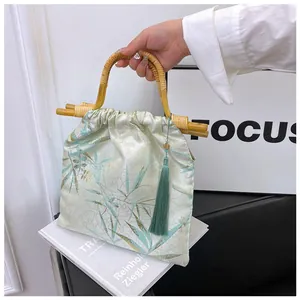 Dettaglio borsa in stile neo-cinese con manico in bambù ed elegante nappa di seta