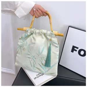 Elegante borsa in nuovo stile cinese con manico in bambù e dettaglio nappa in seta verde