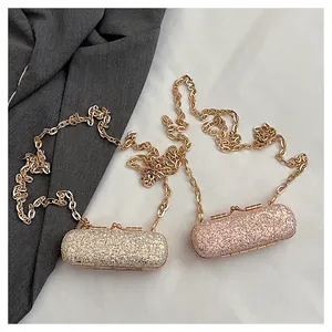 Detail view of two glitter mini lipstick bags with golden chain straps for parties.