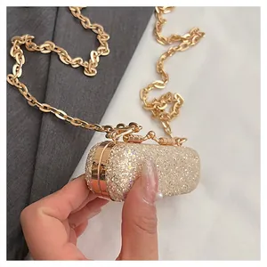 Close-up of an elegant gold glitter mini lipstick bag with a stylish chain strap