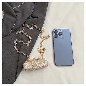 Mini sequined evening bag with gold chain shown next to a phone for size comparison