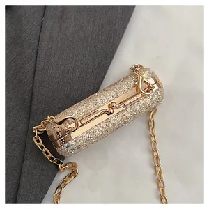 Close-up detail of a glamorous gold sequined mini lipstick bag with a chunky metallic chain strap